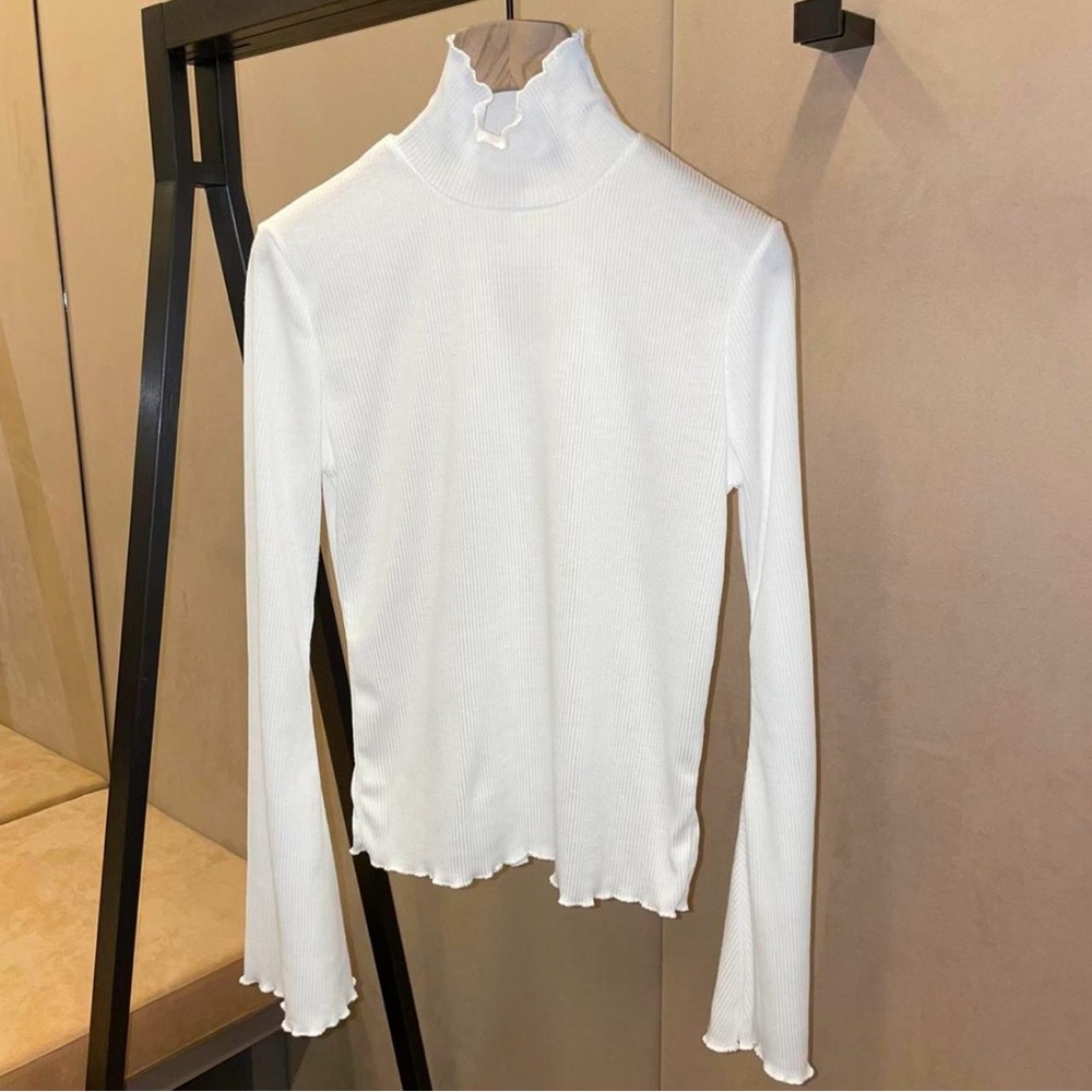Comfortable white roll neck. Featuring soft bell sleeve design.